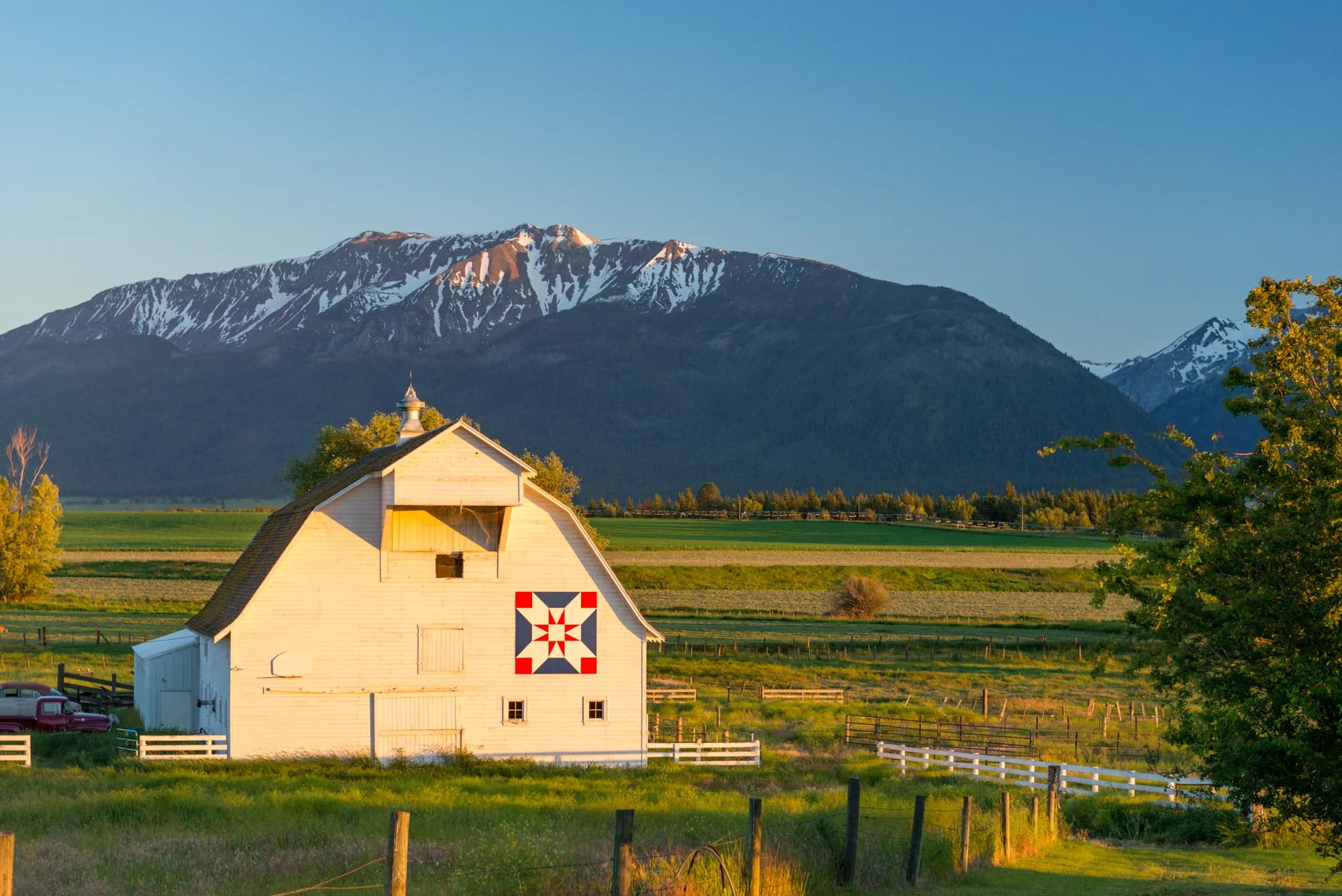 A barn and working fields beneath the Wallowa Mountains